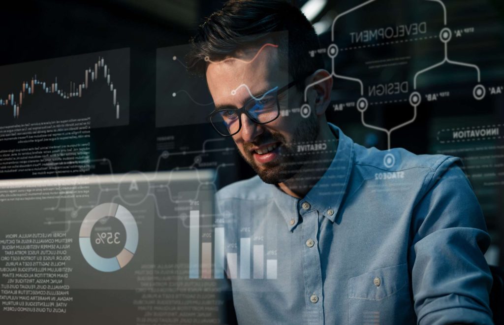Focusing man sitting at table in office using computer having overhours and doing project work.